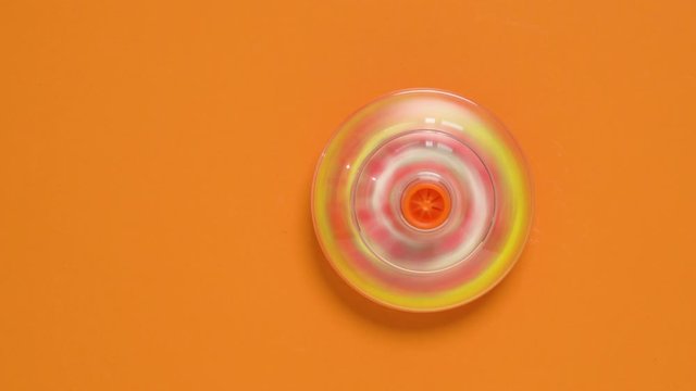 Kids whirligig humming spinner on orange background