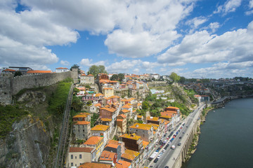 Fototapeta na wymiar Panoramic view of Porto city , the beautiful buildings and their colorful rooftops from both sides and the douro river below , was captured from the Luís I iconic bridge Bridge