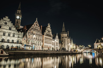 Fototapeta na wymiar Panoramic view of Graslei in the historic city center of Ghent at night with reflections on the Leie river, Ghent, East Flanders, Belgium