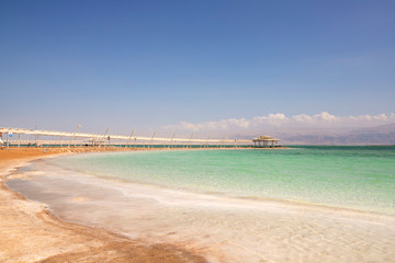View of the salt-covered coastline and sun umbrellas on the Dead Sea beach
