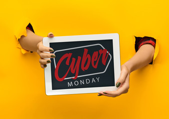 Hands holding tablet screen with black friday lettering on yellow background. Concept of sales,...