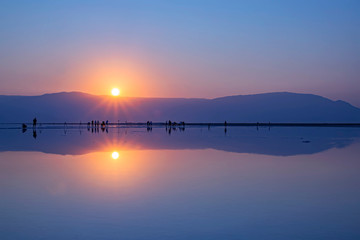 A group of photographers taking pictures of sunrise on the shore of the Dead Sea