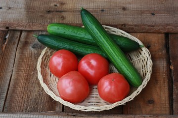 Fresh cucumbers and tomatoes on a wooden table