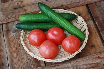 Fresh cucumbers and tomatoes on a wooden table