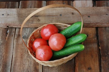 Fresh cucumbers and tomatoes on a wooden table