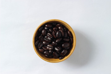 Isolate coffee beans on wooden bowl on white background