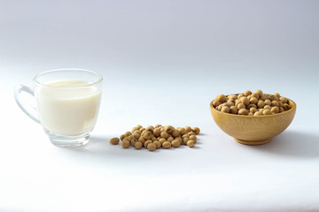 Closed up heap of soy beans on white floor and mini wooden bowl. The benefit of soy beans so much and popular for made some soy milk. This is the important ingredients for vegtarian.
