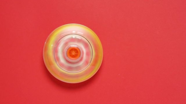 Colorful spinning top toy on red background