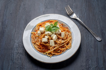 Spaghetti pasta with fresh and parmesan cheese on dark background