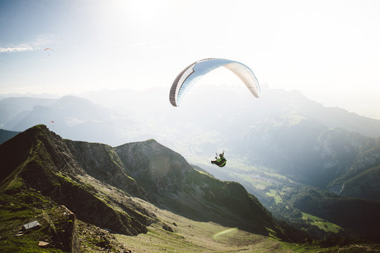Person Paragliding im blauen Himmel gegen die Sonne