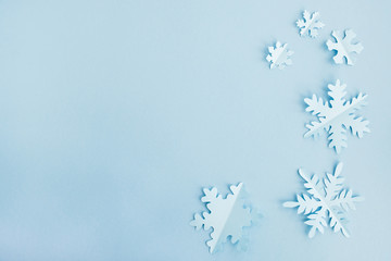 Winter and christmas concept. Snowflakes made of paper on a light blue background. Background for design, minimal composition. Top view, flat lay, copy space