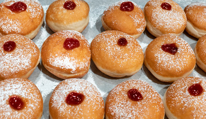 Fresh donuts  with chocolate at the bakery display for Hanukkah celebration. Selective focus.