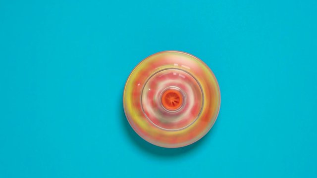 Colorful spinning top toy on blue background