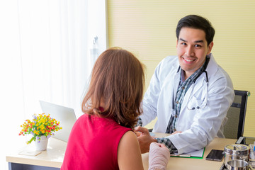 The doctor is interviewing the symptoms of Asian female patients. About broken arm for diagnosis Next time treatment With modern medicine in the medical room.