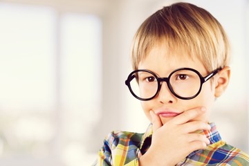 Cute little schoolgirl in glasses with book on  background