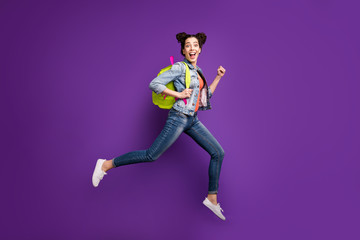 Fototapeta na wymiar Full body profile photo of funny student lady jumping high rushing home after last studying day wear green bag casual denim outfit isolated purple color background