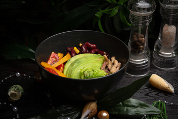 chicken bowl in a black plate on a dark wooden background