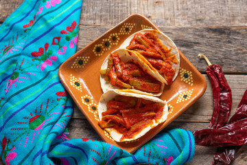 Mexican nopal cactus tacos with guajillo red sauce on wooden background © Guajillo studio