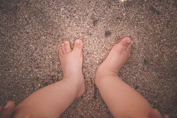 Pieds d'un bébé dans le sable - 299342220