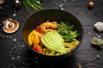 shrimp bowl with avocado in a black plate