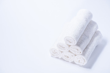 Fototapeta na wymiar Gently rolled terry towels for spa or massage on a white background