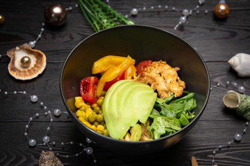 shrimp bowl with avocado in a black plate