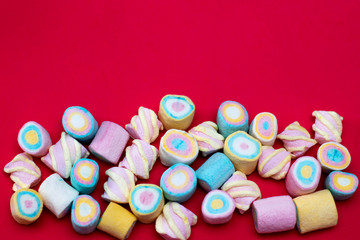Multi-colored sweets on a red background. Holiday Marshmallows