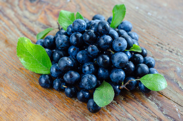 Blueberries with blueberries leaves  on the wooden table.