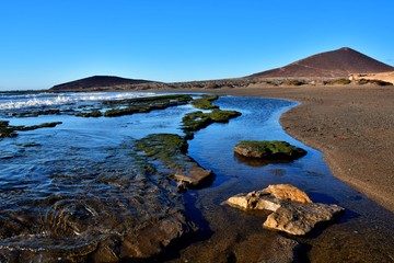 Fototapeta premium El Medano, rocks and puddles at low tide
