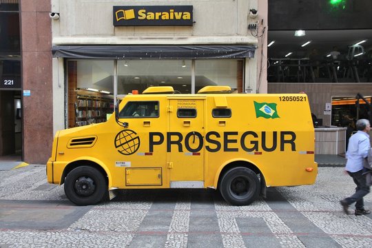SAO PAULO, BRAZIL - OCTOBER 6, 2014: People pick up money from store in armored vehicle in Sao Paulo, Brazil. Robberies and other violent crimes are frequent in Brazil.