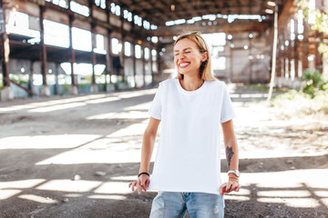 Girl wearing white t-shirt, glasses and leather jacket posing against street , urban clothing...