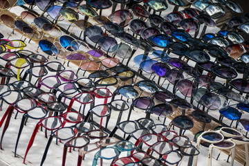 Display de anteojos falsificados de lectura y de sol en venta callejera. 