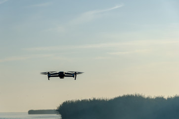 Fototapeta na wymiar Drone copter with digital camera, blur river on background.