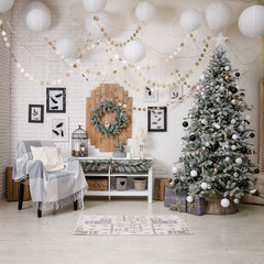 Modern black and white interior design room with Christmas and New Year decorations, toys, gifts, snow-covered fir tree, garlands. Winter holidays composition.