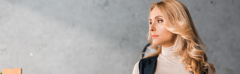 Fototapeta premium panoramic shot of attractive businesswoman looking away in office