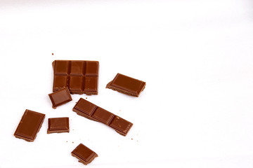 Pieces of milk chocolate on a white background.