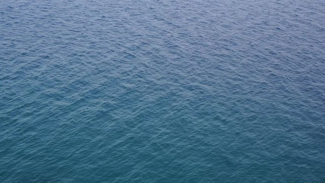 Aerial top view of texture of calm sunny water of sea. Beautiful natural video background. Real time full hd footage.