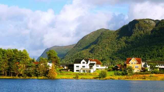 Alesund, Norway. View of the typical houses by the mountain and lake in Alesund, Norway during a sunny autmn day with cloudy sky, zoom out