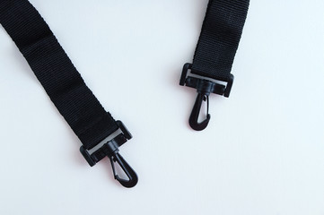 Close-up black textile handle for a bag with plastic carabiners.
