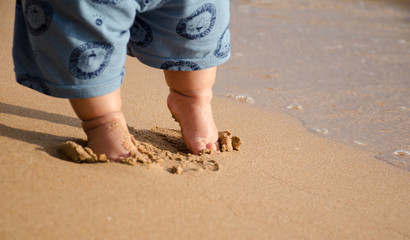 Fototapeta na wymiar Child feet at the sand