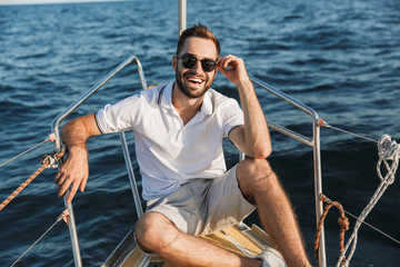 Man outdoors posing on yacht in sea.