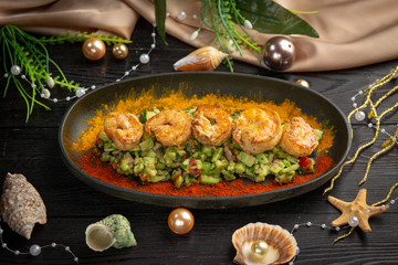 tartar shrimp with avocado and spices on a black oval plate