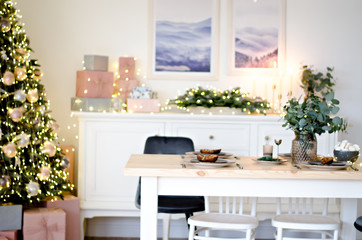 Christmas table in the kitchen with a festive Christmas tree decorated with toys. New Year's cuisine.