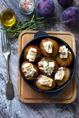 Baked plums with white cheese and herbs. Keto diet. Selective focus. Macro.