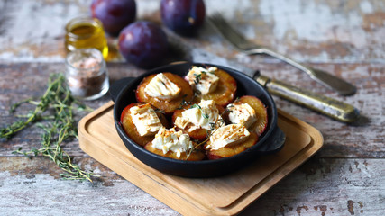 Baked plums with white cheese and herbs. Keto diet. Selective focus. Macro.