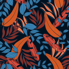 Fashionable abstract seamless tropical pattern in bright colors on dark blue background.  Jungle leaf seamless vector floral pattern background. Beautiful exotic plants. 