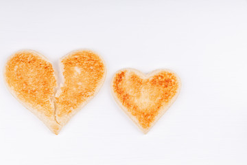 Bread toast broken heart with whole heart together on white background. The concept of divorce, breakup, unhappy relationship.