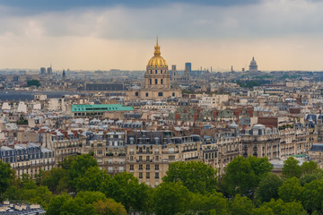 Beautiful aerial cityscape view of Paris with the golden dome of the Les Invalides complex surrounded by the typical Parisian residential buildings on a summer day. 