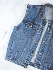 Closeup of vintage denim vest isolated on white linen background. Flat lay. Top view. Copy space
