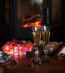 Glasses of drink are on the table by the fireplace